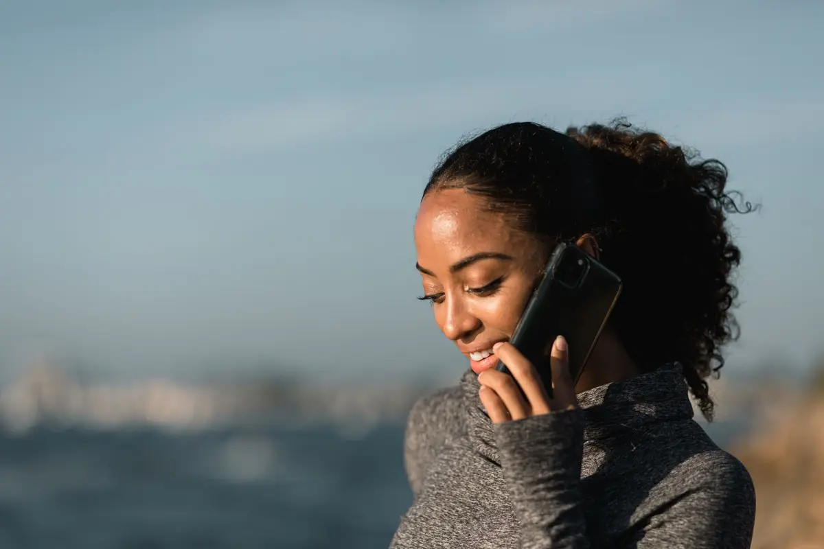Mujer con suéter gris revisando su celular