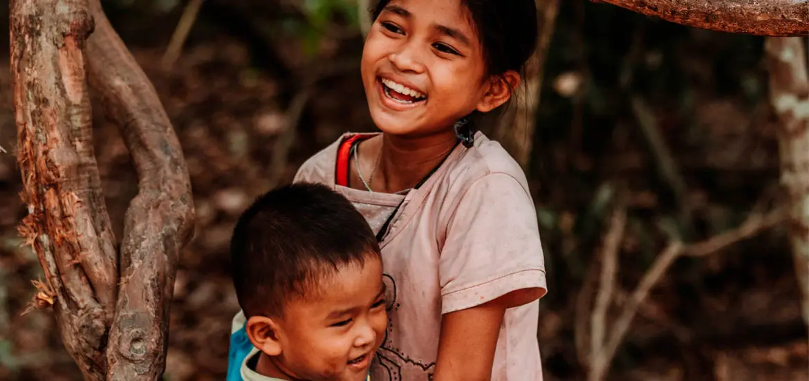 Niña sonriente abrazando a un niño pequeño