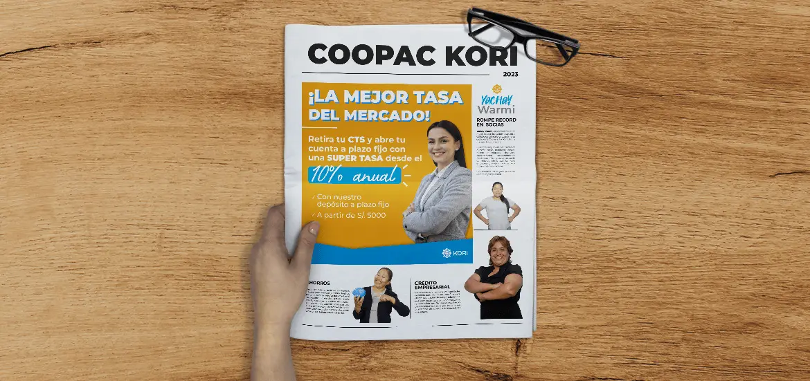 Periódico "Coopac Kori" sobre mesa de madera