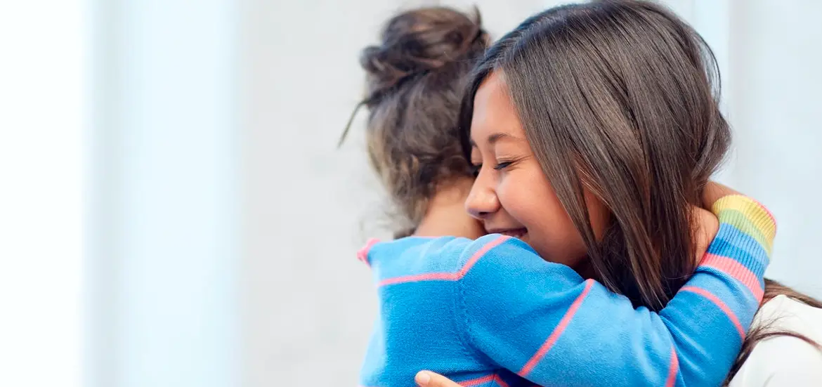 Mujer abrazando a una niña