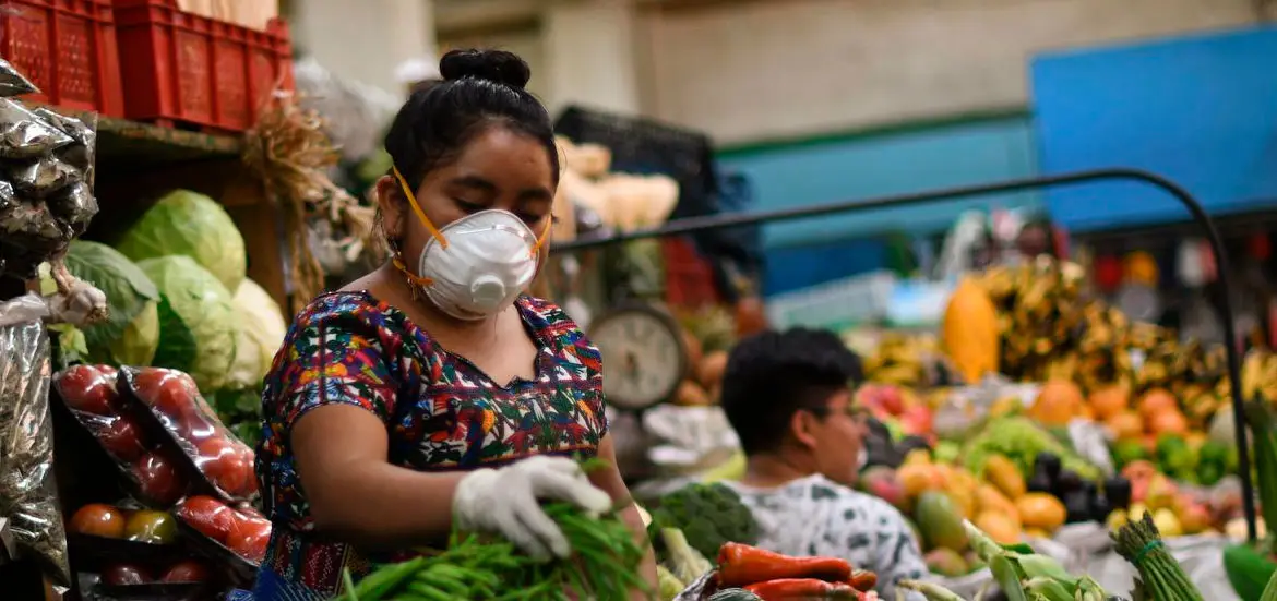 Vendedora de mercado con mascarilla y un niño